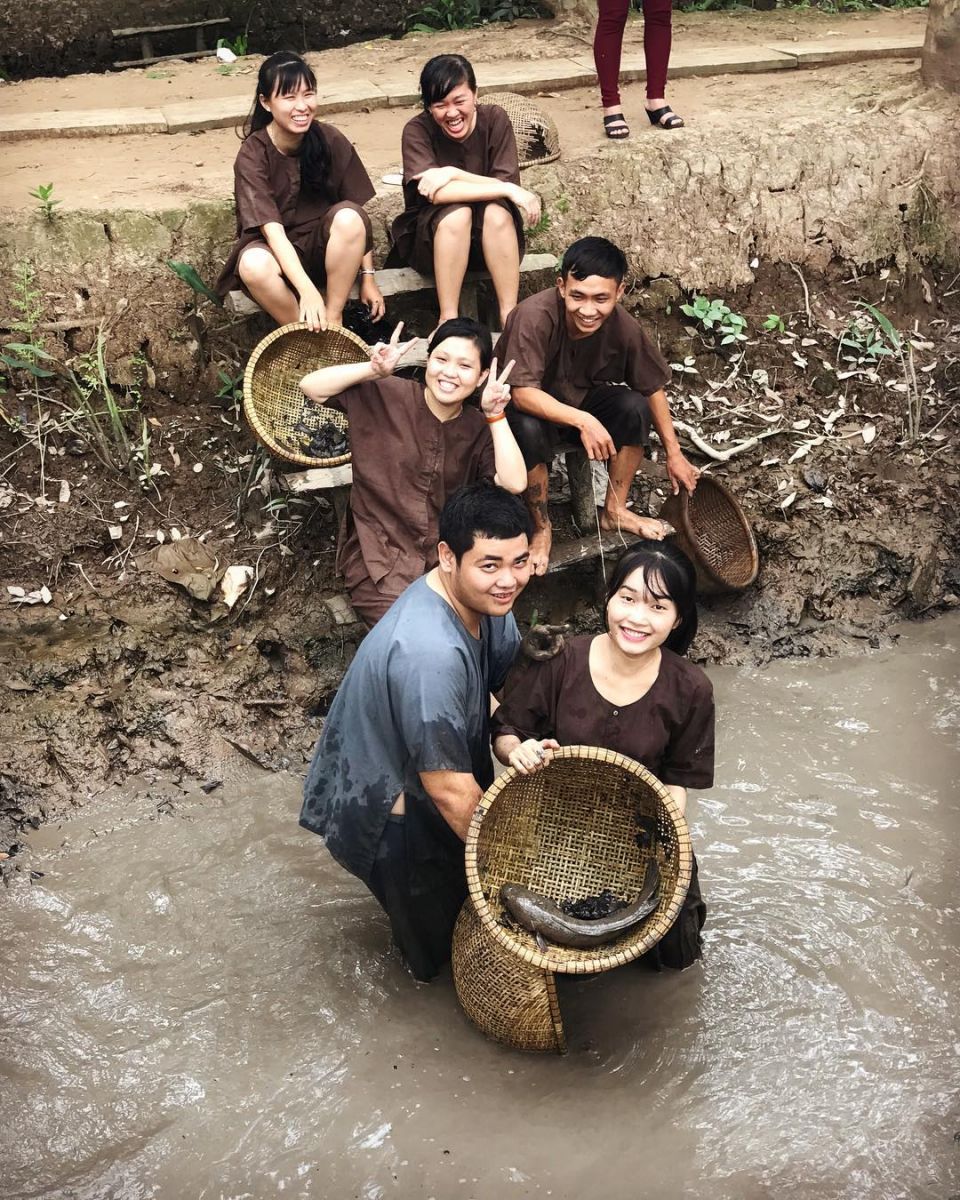 Du khách trong trang phục đồ bà ba tham gia tát mương bắt cá